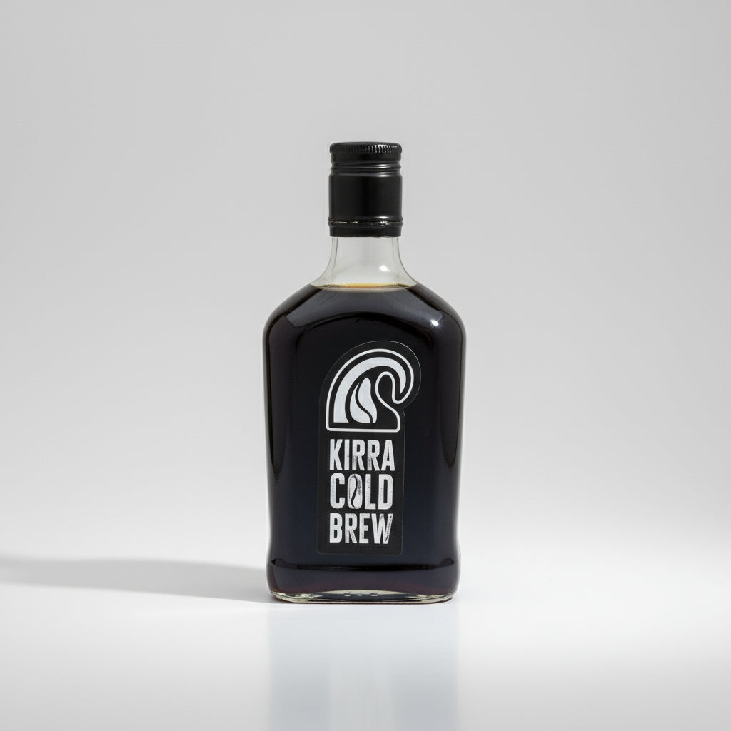 Bottle of Kirra Cold Brew on a beach with waves in the background